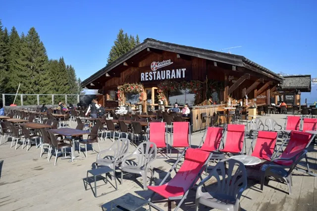 Restaurant d'altitude avec terrasse transat sur les pistes grand ciel bleu vu sur la montagne à Saint-Gervais-LesBains face au Mont Blanc